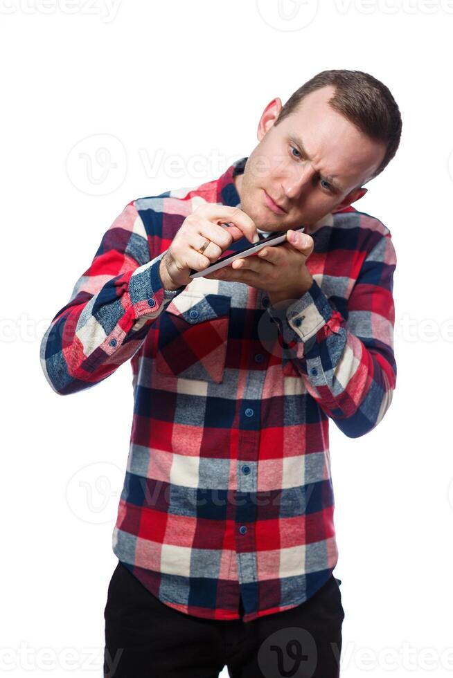 white-skinned male freelancer, repairman, scratches the protective film on the tablet screen and removes it. wearing a shirt. Emotional portrait. Isolated on white background photo