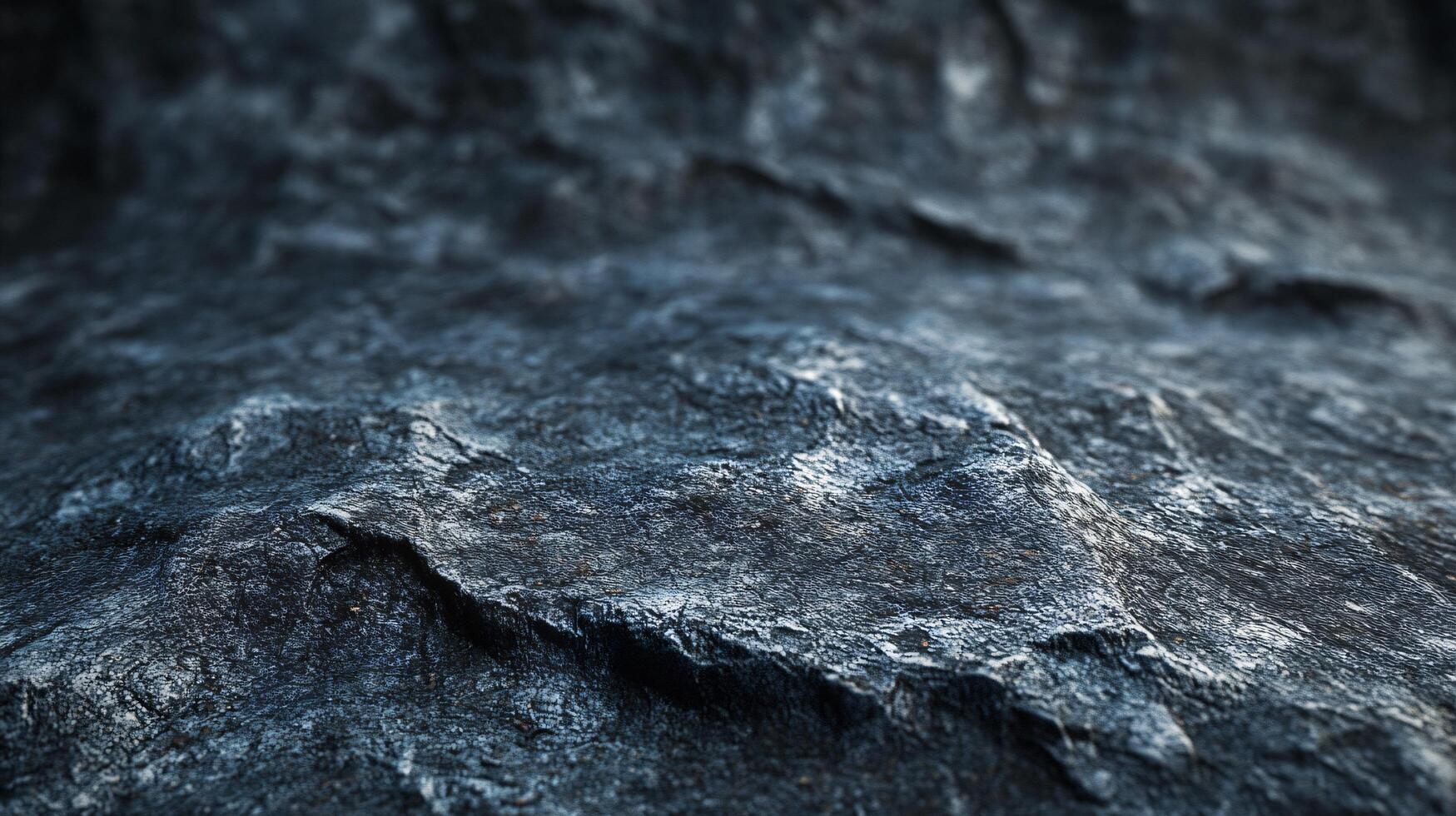 The image is of a rocky shoreline with a dark blue color. The rocks are jagged and rough, and the water is choppy. Scene is one of ruggedness and wildness, with the rocky shoreline photo