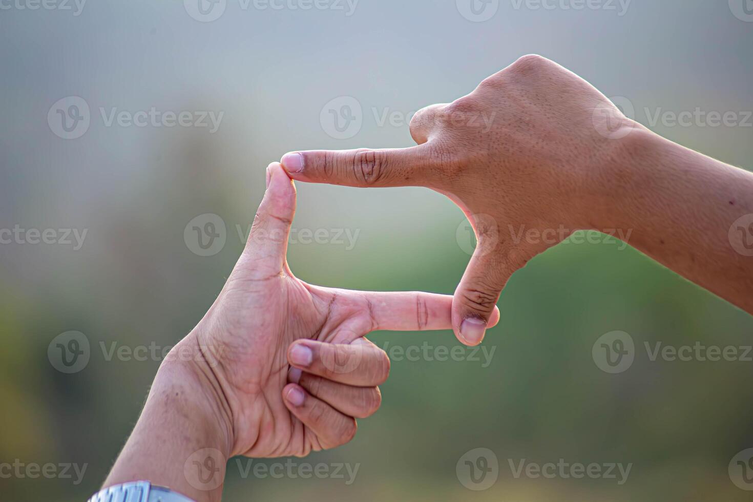 Hands of person making frame distance or symbol in nature. photo