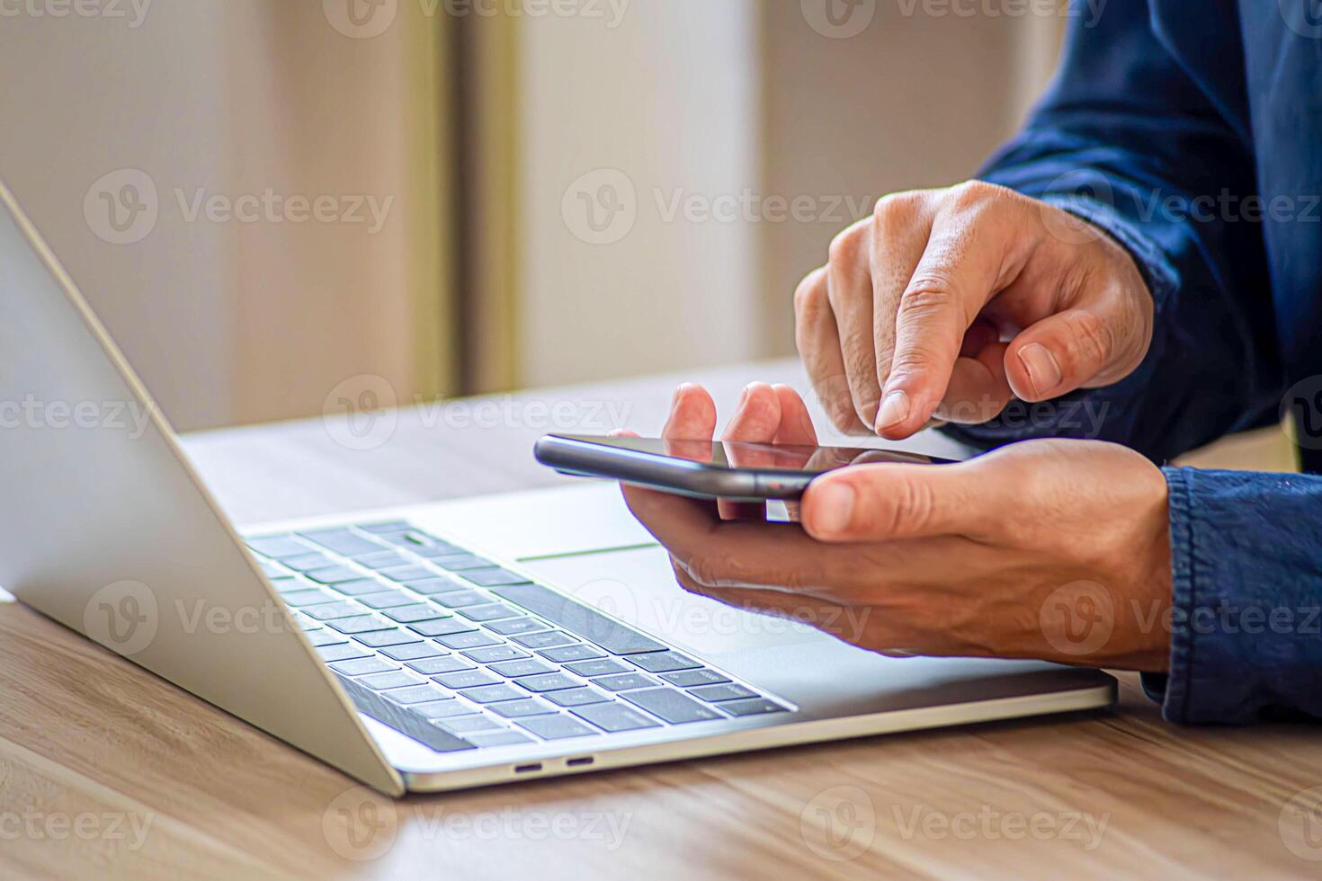 Woman working online on the keyboard of her laptop computer While holding the phone photo