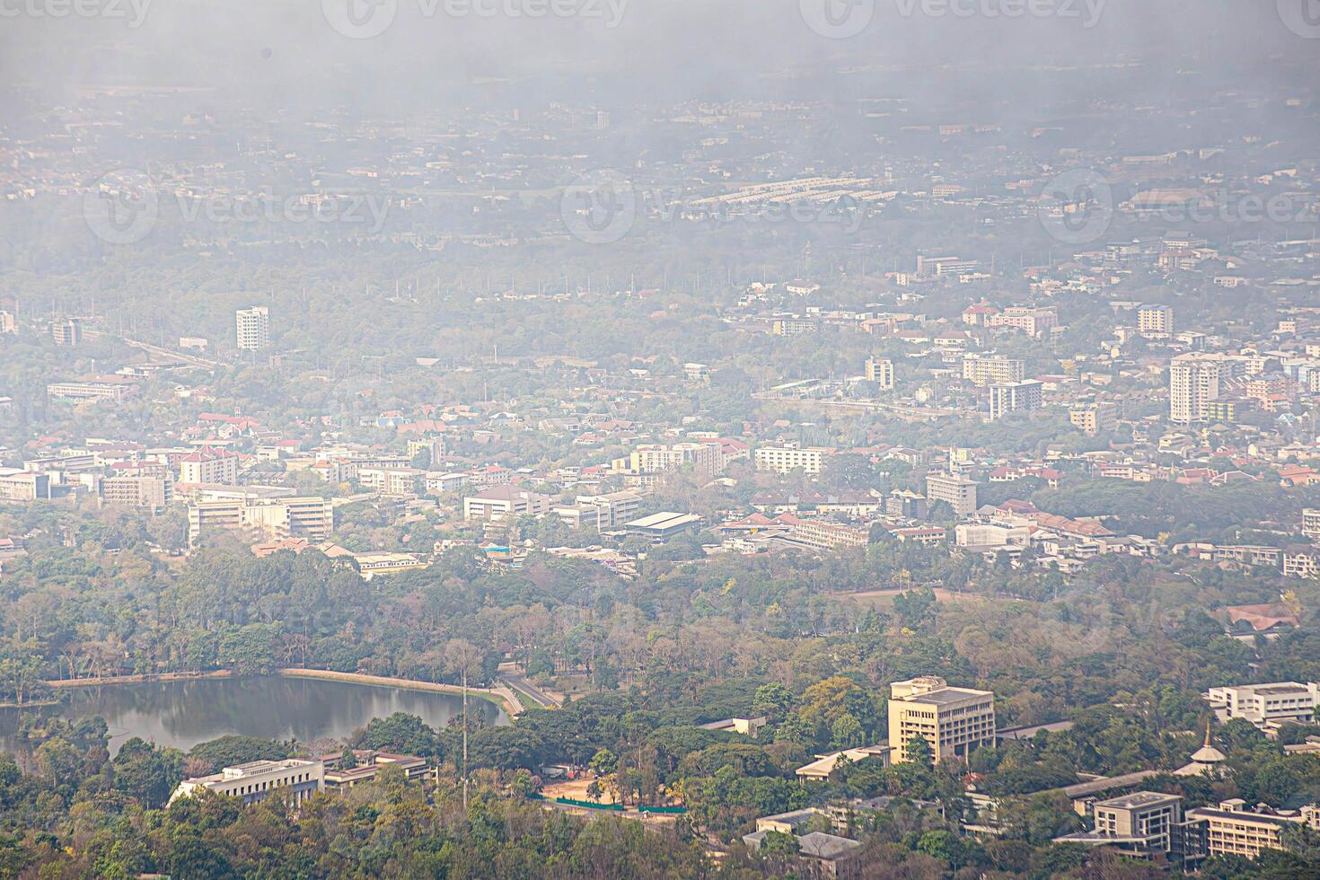 a plane flying over a city with trees and buildings photo