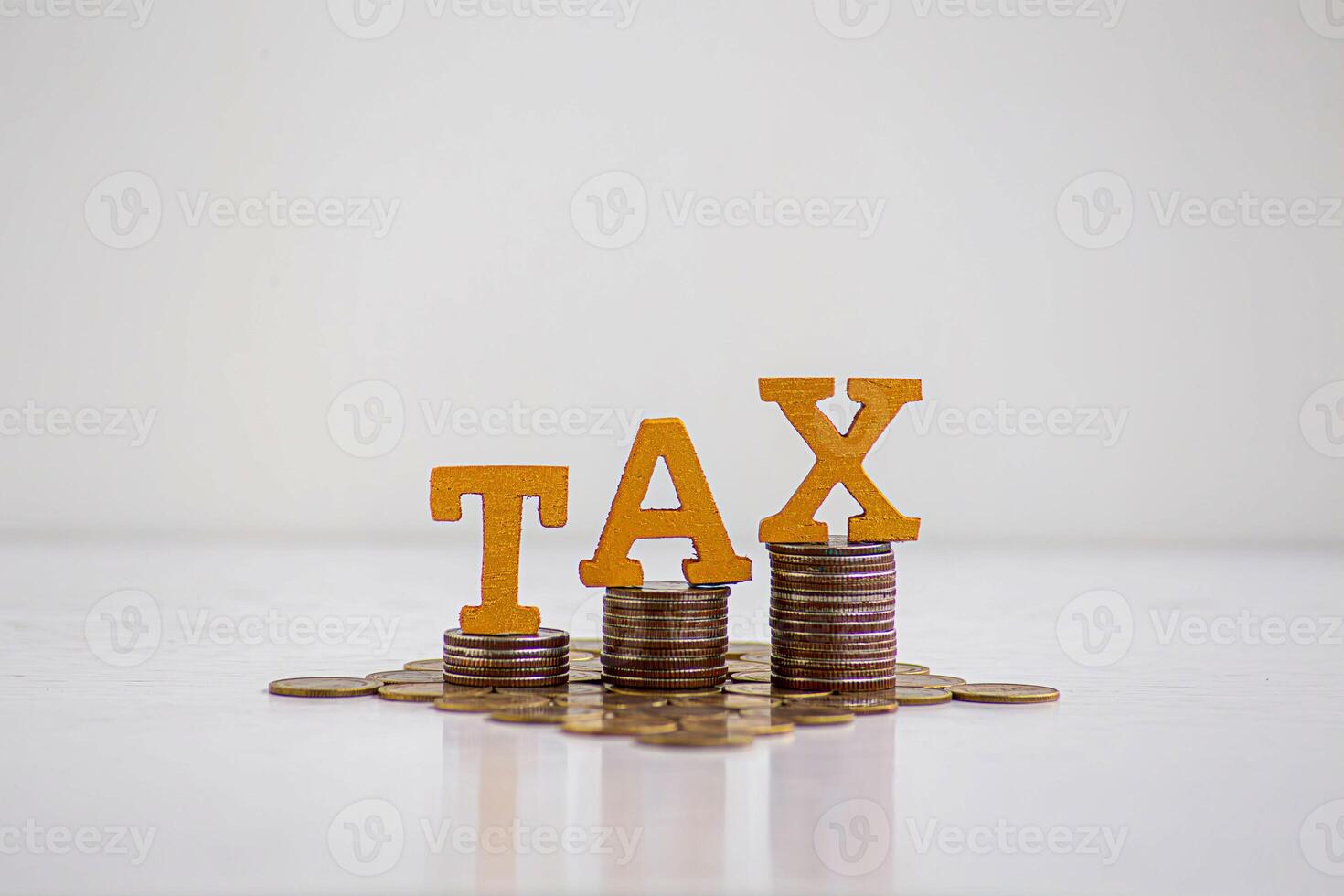 TAX Concept.Word tax put on coins with calculator and summary report on table. photo