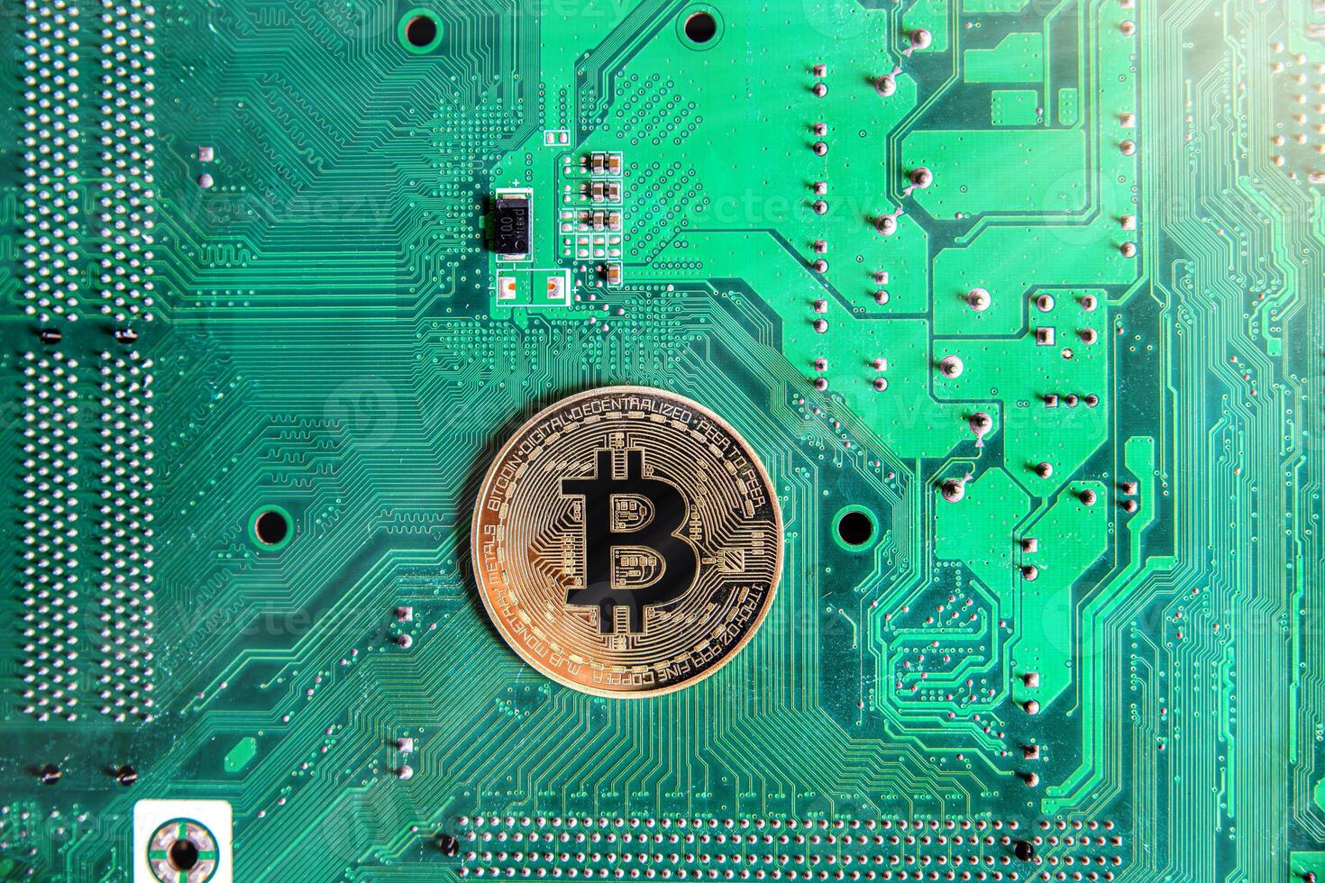 Gold souvenir coin Bitcoin on a computer circuit board background. photo