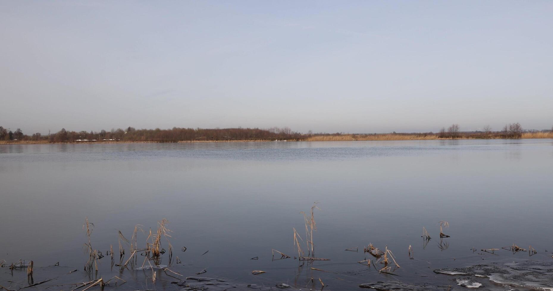 dark muddy lake water in winter without snow photo
