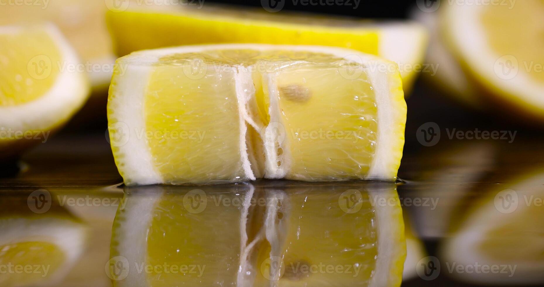 ripe sliced lemon and its reflection on a wet table photo