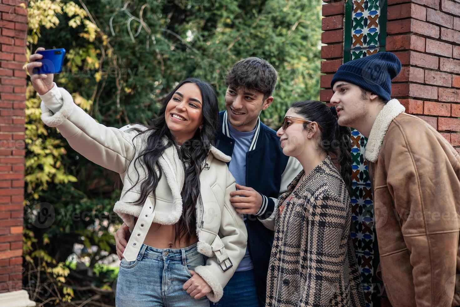 group of four young friends taking selfie with the phone photo
