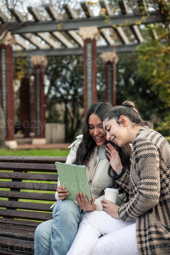 portrait vertical two girls greeting making call with tablet photo