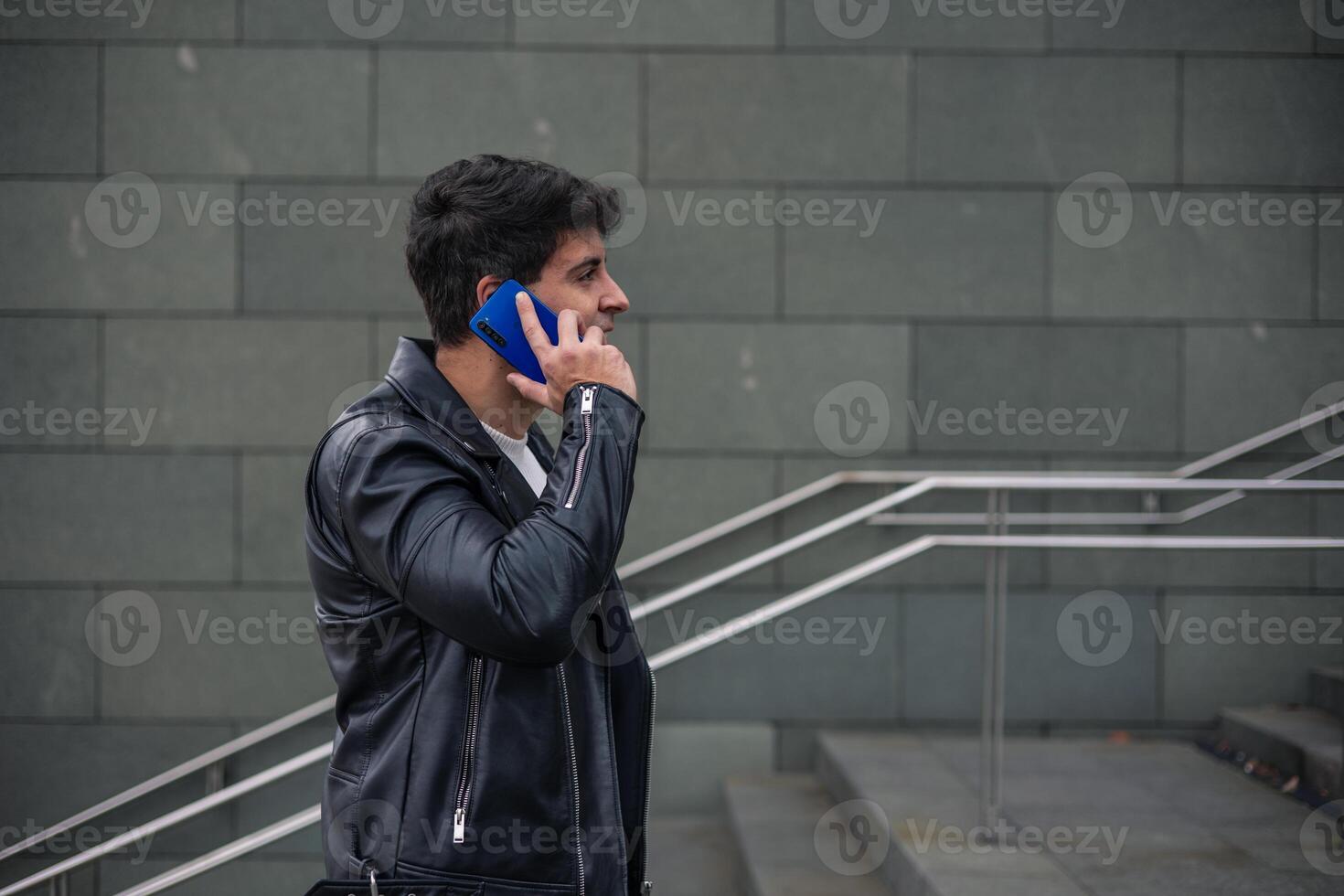 close-up young man talking on cell phone on stairs photo