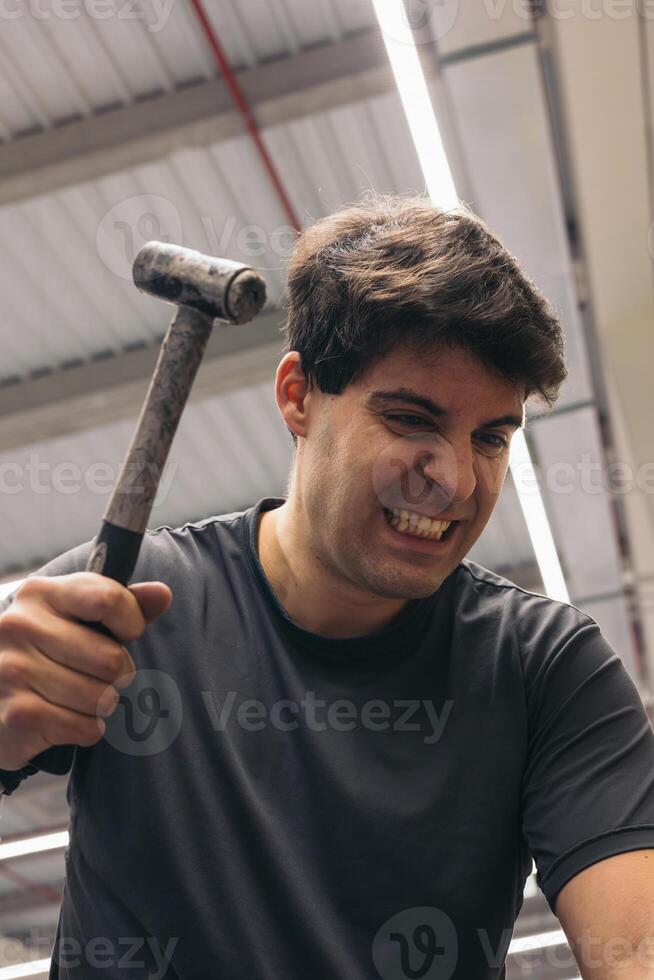 angry man hitting with hammer photo