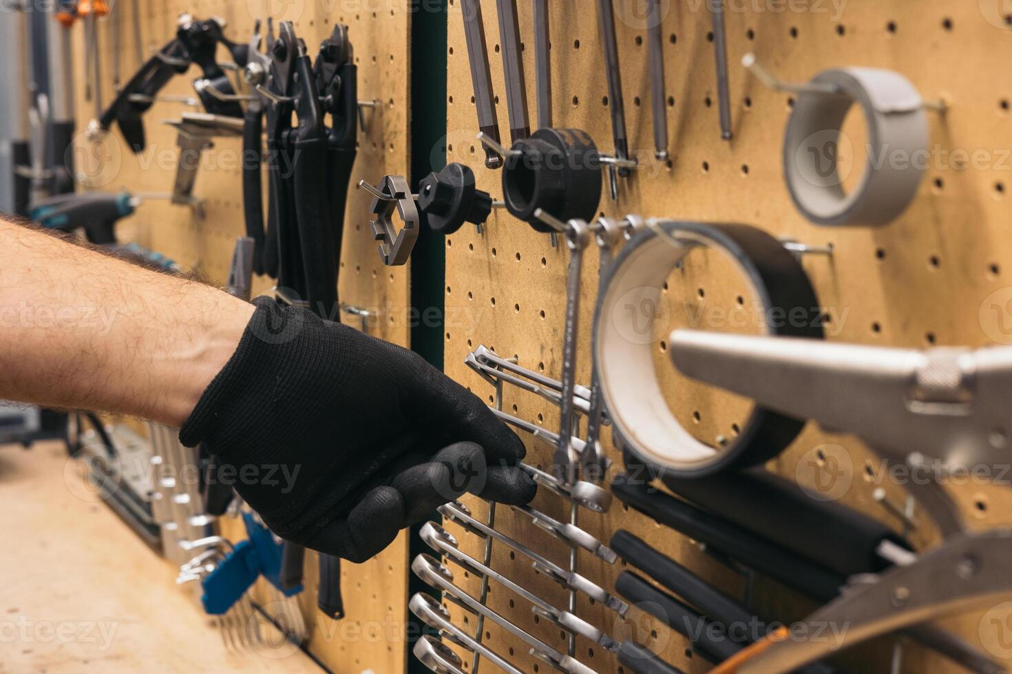 closeup hand with glove taking spanner in workshop photo