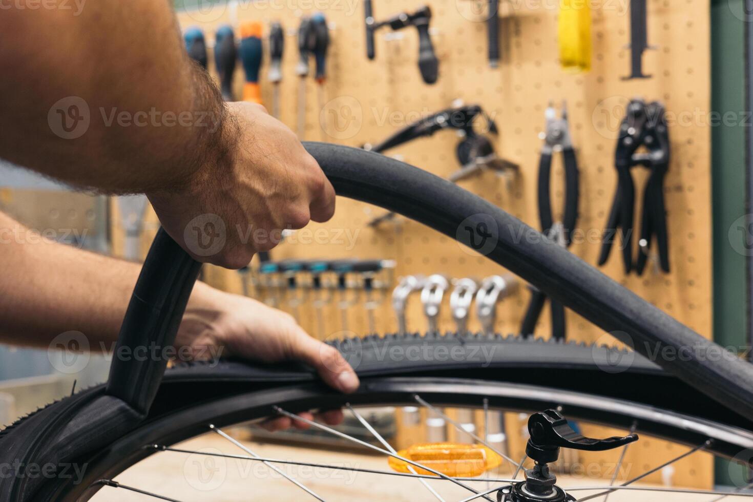 closeup hand removing flat tire from bike in workshop photo