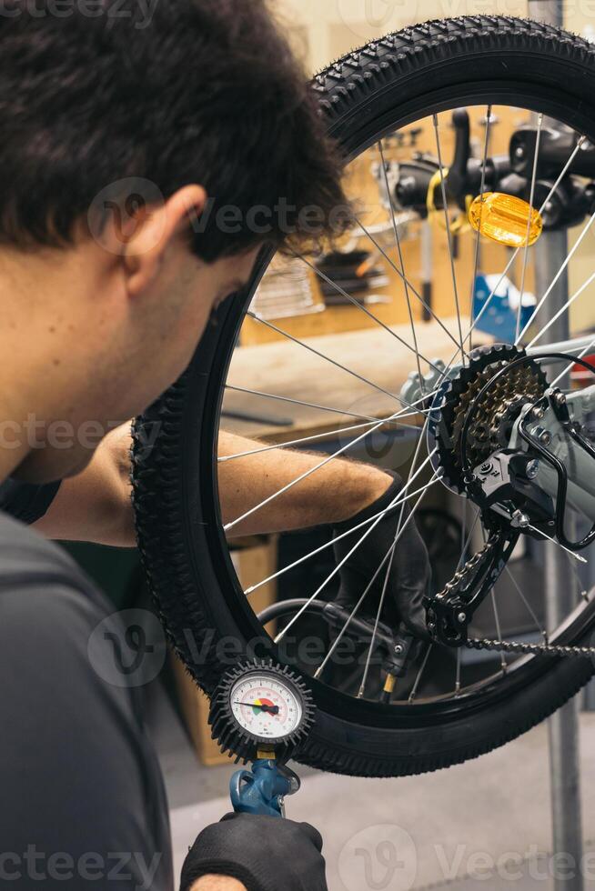 vertical bike mechanic inflating tire with air compressor photo