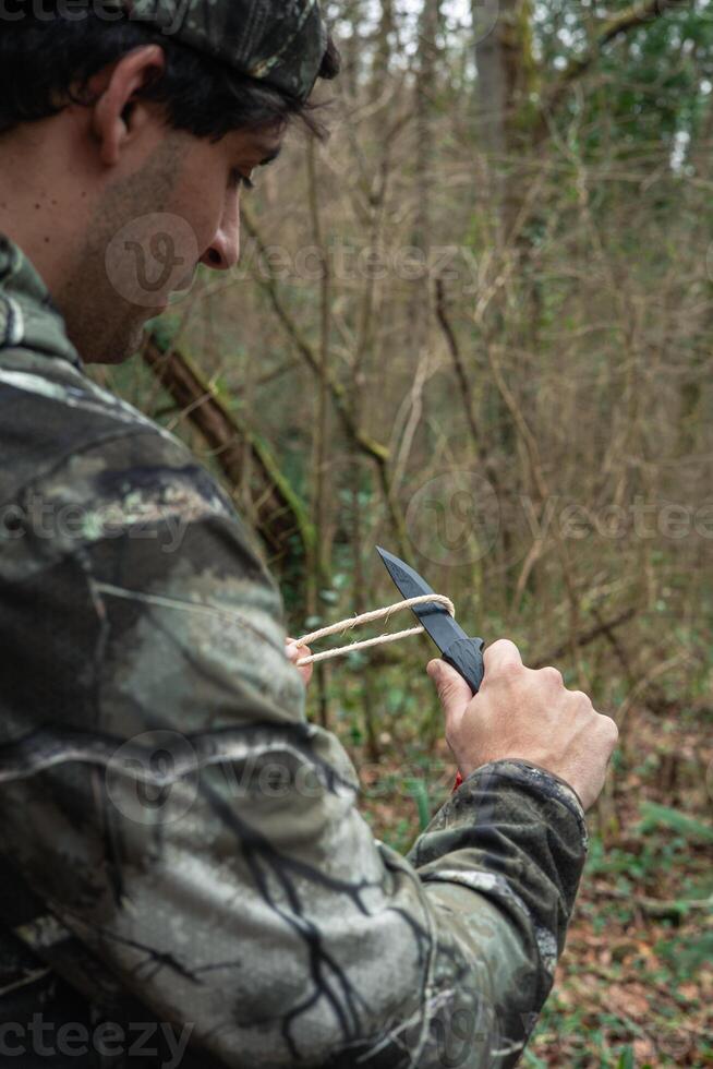 closeup from behind Conquering Nature Explorer Cutting Rope in the Forest photo