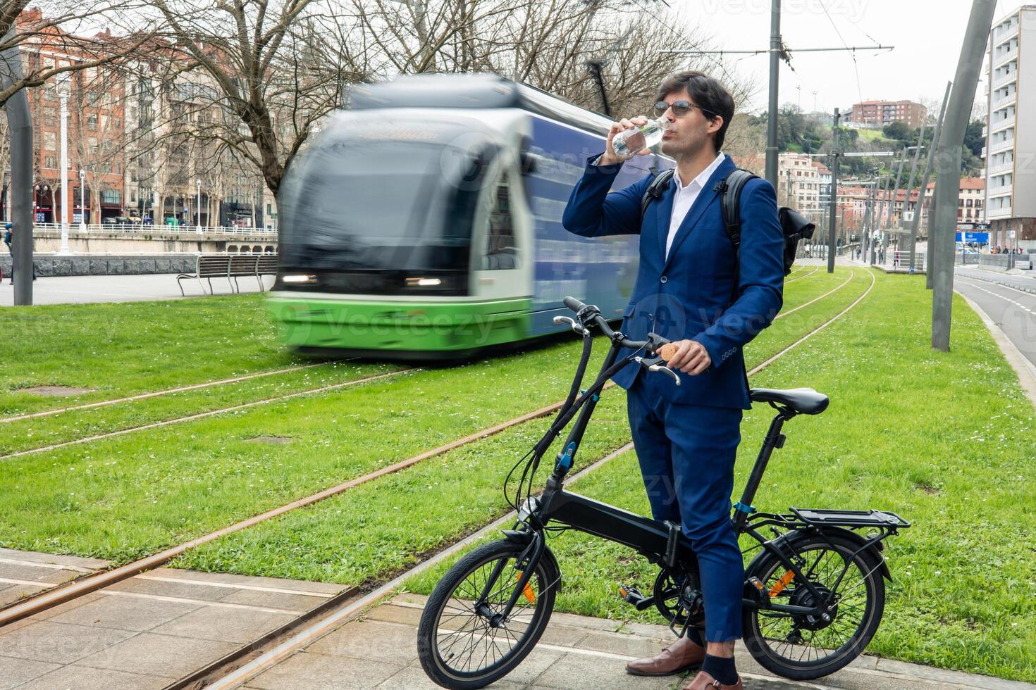 Urban Commuter Businessman Taking a Refreshing Break with Electric Bike photo