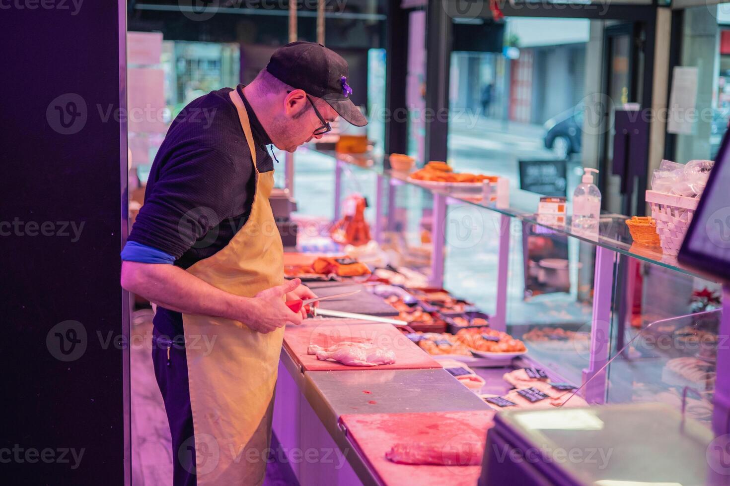 Butcher Sharpening Knife at Butcher Shop Counter photo