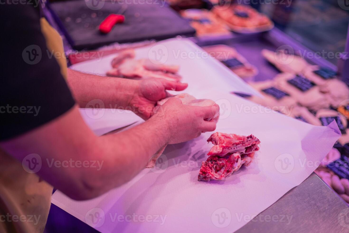 Closeup of Butcher's Hands Preparing Meat Order for Customer in Butcher Shop photo