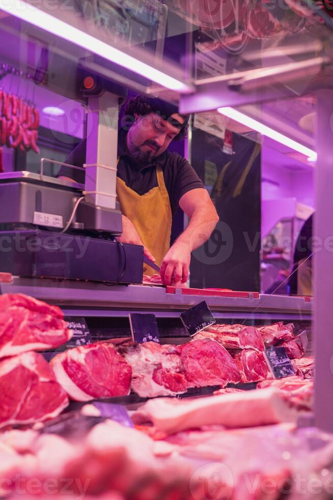 vertical portrait Butcher slicing meat behind counter photo