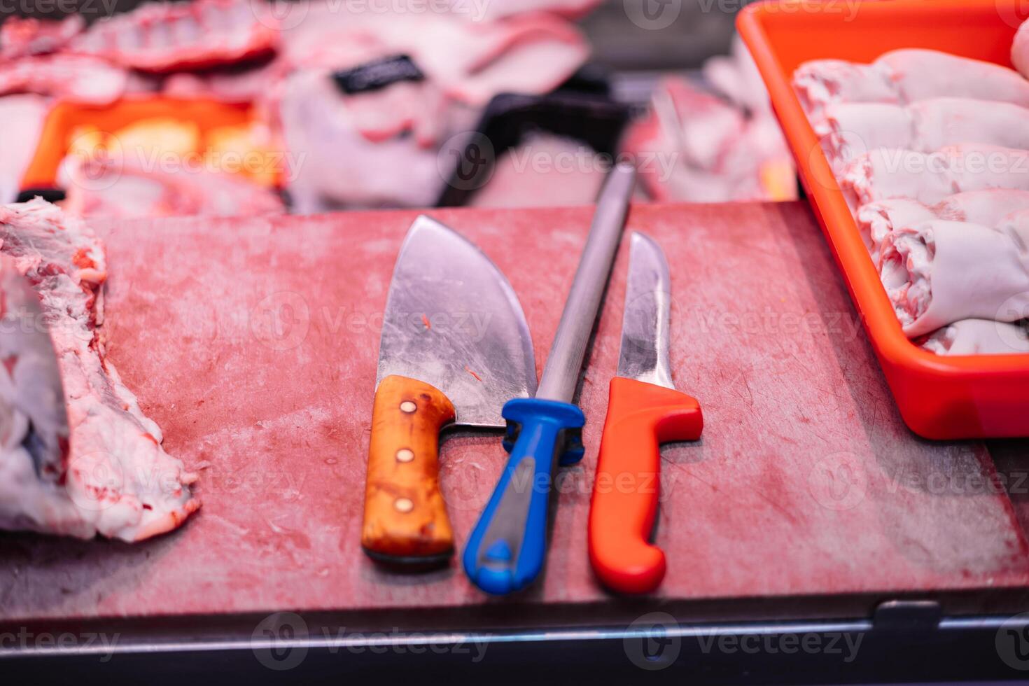 closeup Two Butcher Knives and Knife Sharpener on Meat Cutting Board in Butcher Shop photo