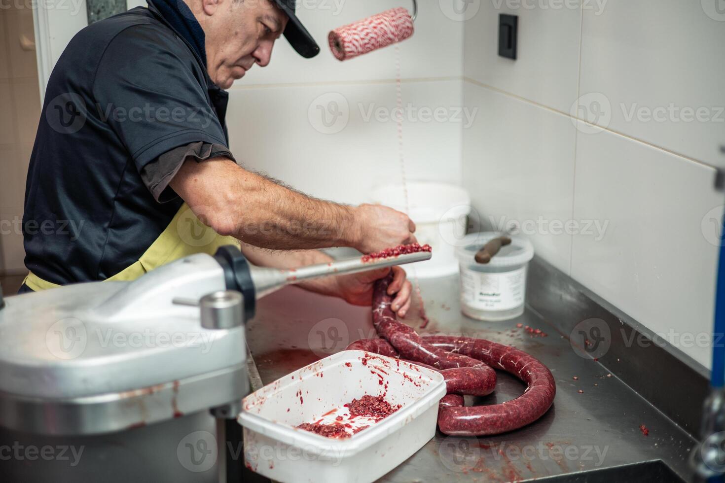 closeup copyspace elderly Butcher Finishing Preparation of Large Sausage in Butcher Shop photo