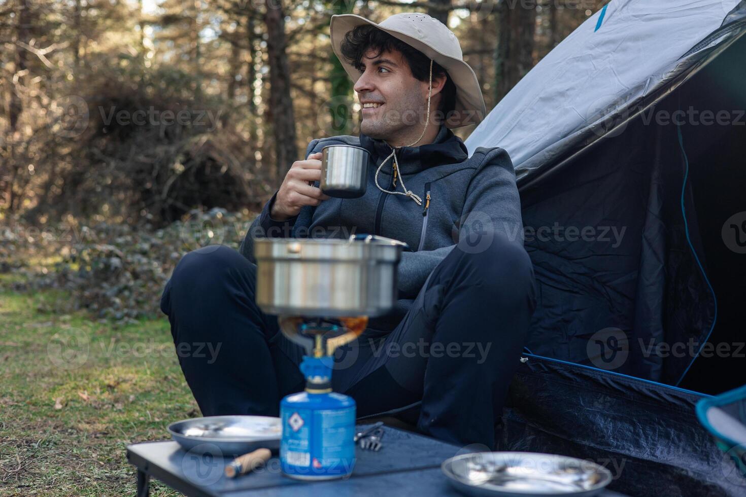 Camper Enjoying Coffee While Camping in Nature photo