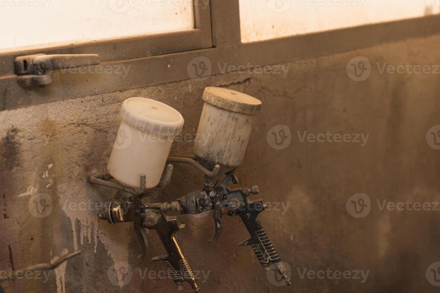 Professional Paint Sprayers Hanging in Workshop photo