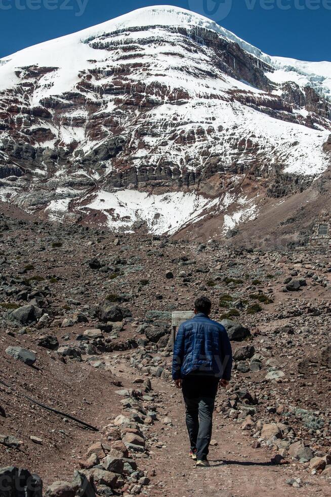 vertical Mountaineer seen from behind walking towards the summit of Chimborazo volcano in Ecuador photo