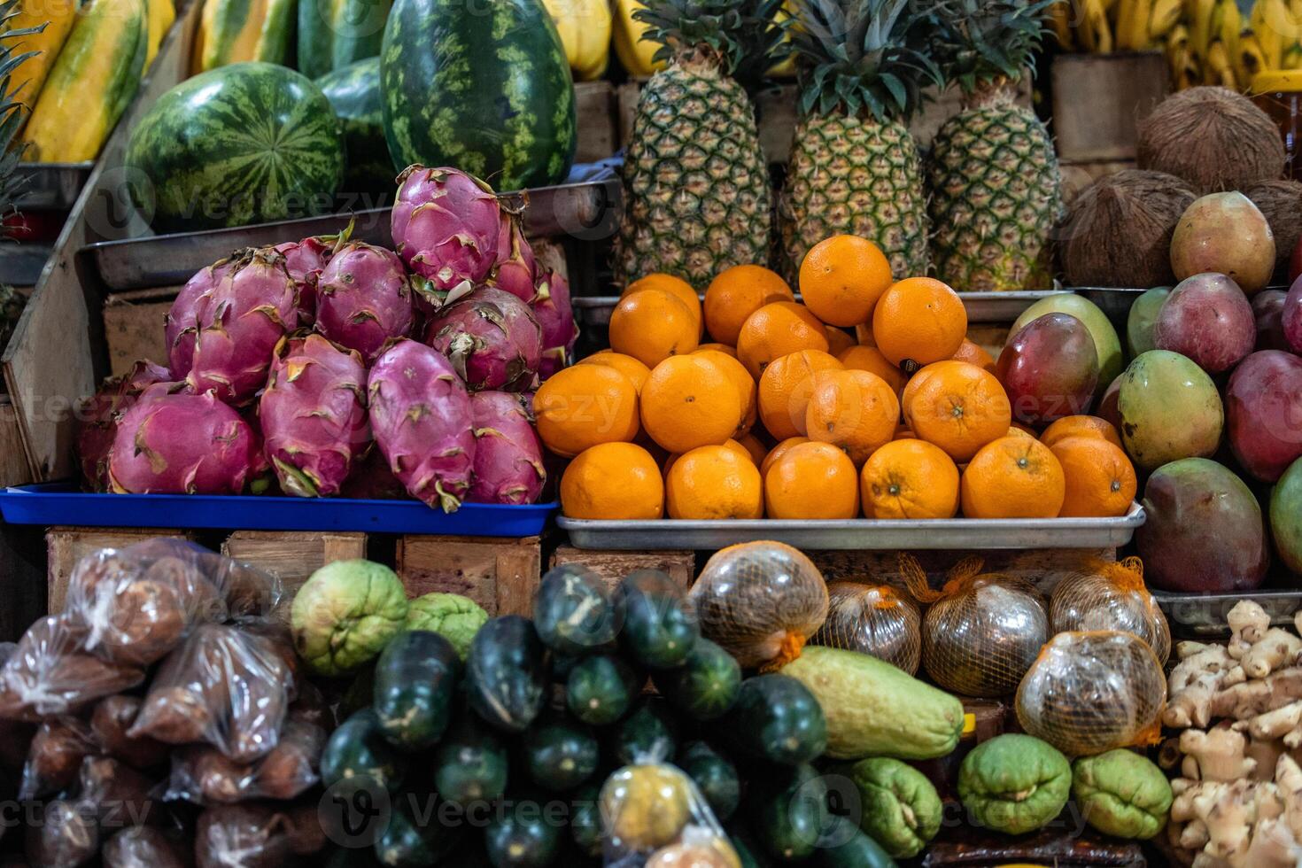 tropical fruits in a traditional market, including coconut, pitahaya, pineapple, mango, and ginger photo