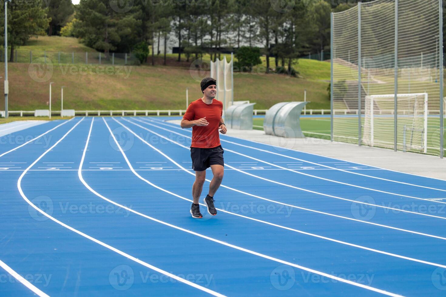 Athletic Man Running on a blue Track photo