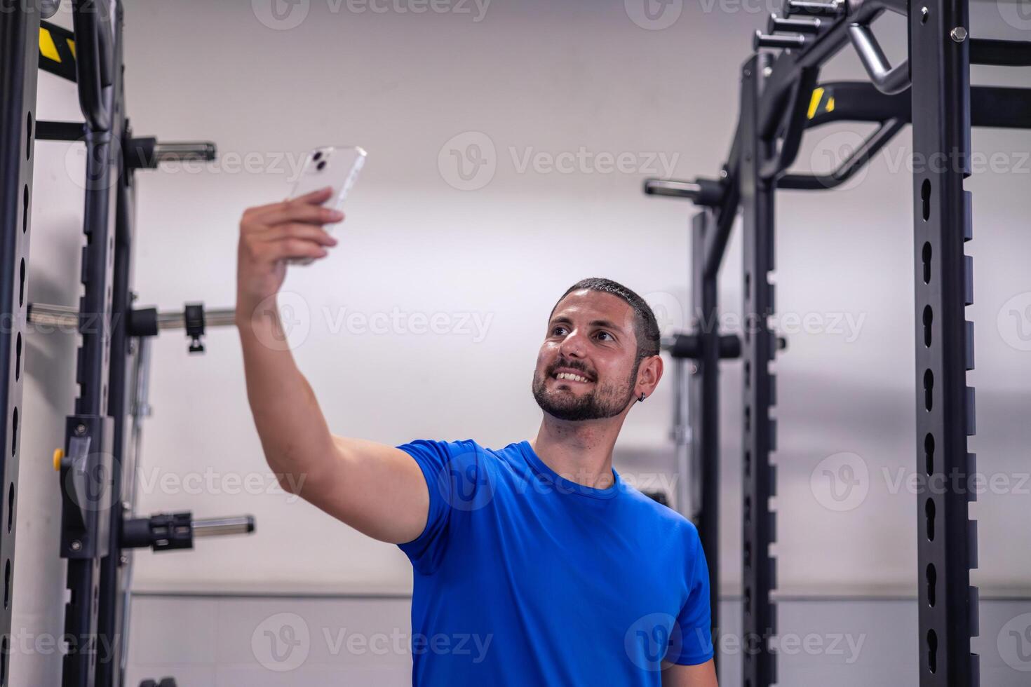 young athlete taking selfie with cellphone during gym workout break for social media photo