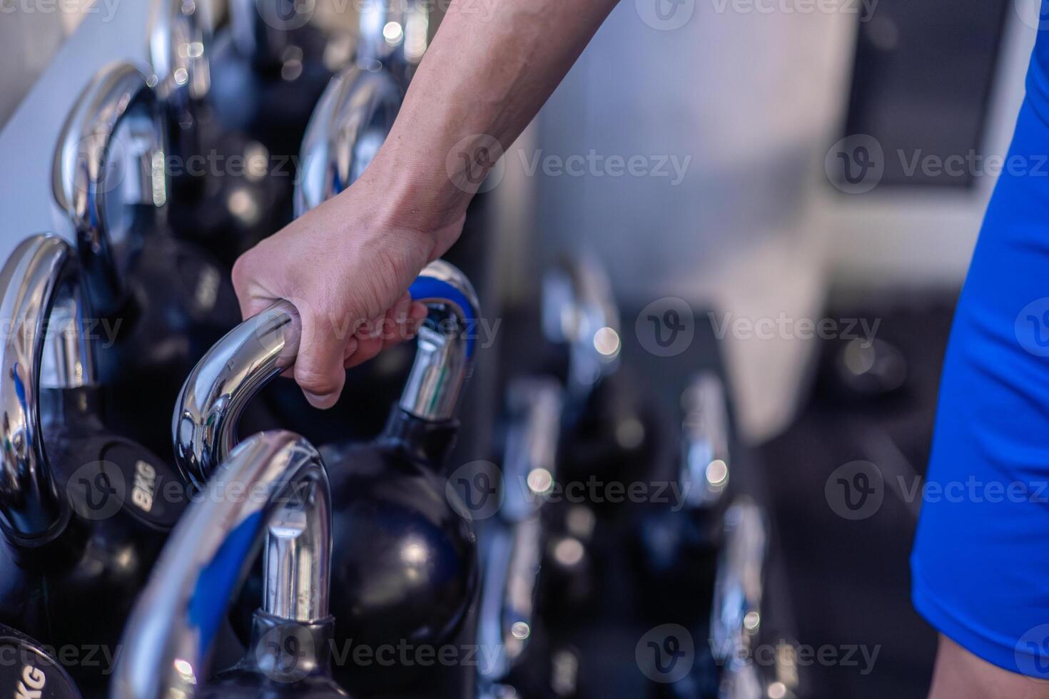 closeup hand of athlete gripping kettlebell for strength training in gym photo