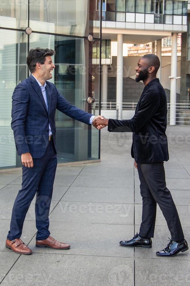 vertical Multicultural Businessmen Shaking Hands in Financial District photo