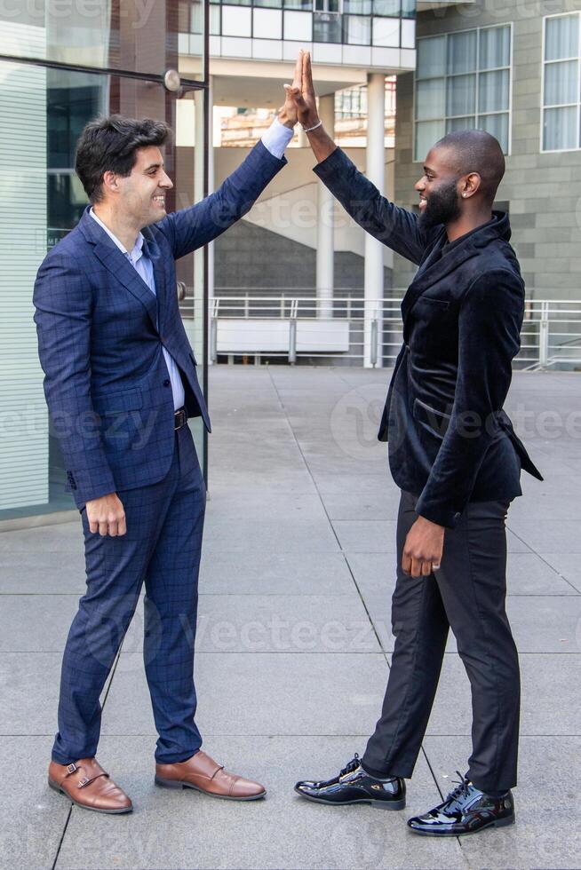 vertical Urban Business Diversity African and Hispanic businessmen fist bump in financial district photo