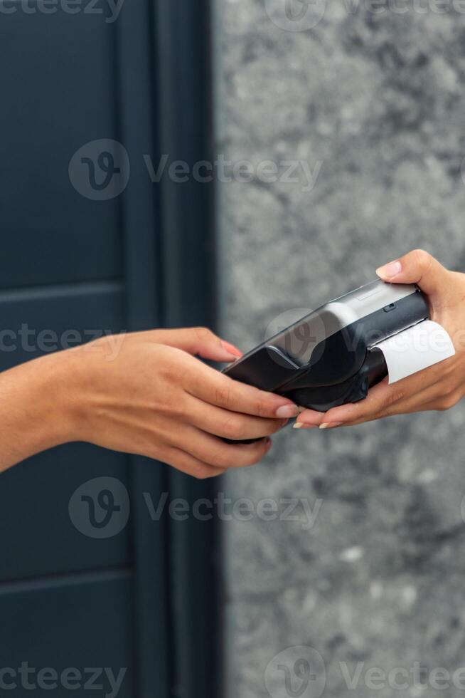 Closeup of hand entering PIN on payment terminal offered by vendor photo
