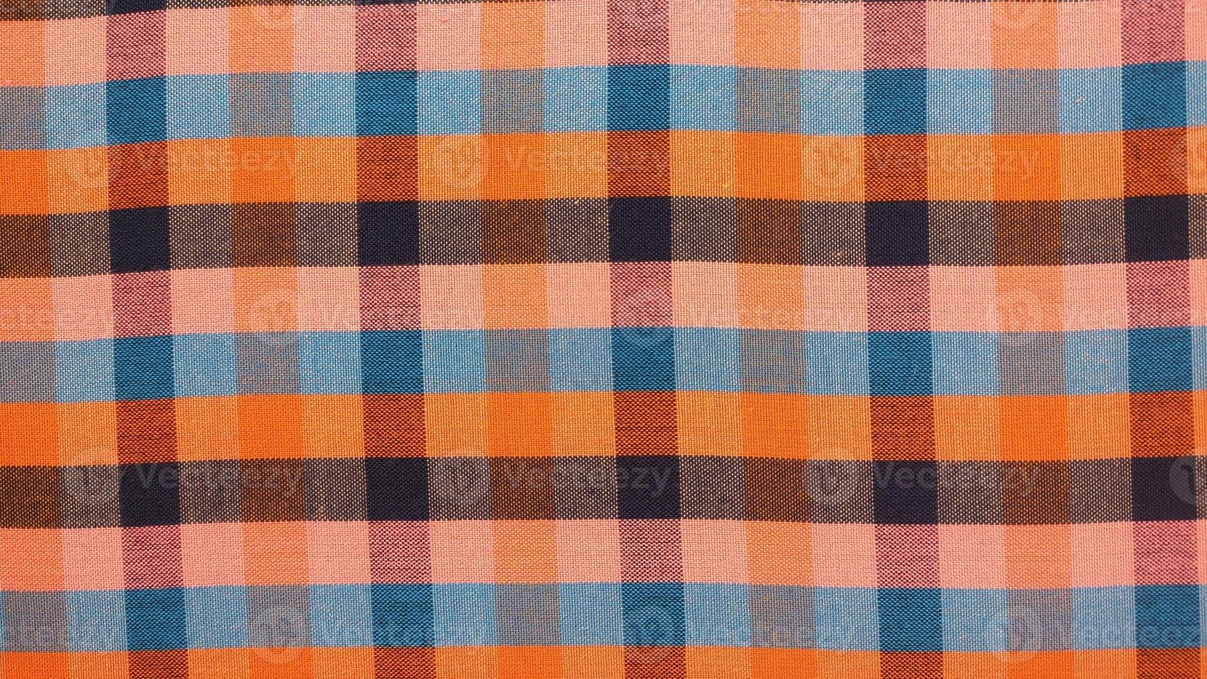 A checkered patterned fabric with blue, orange, and purple colors photo