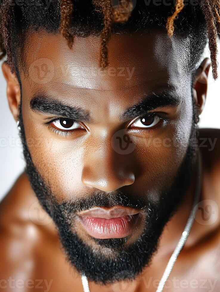 Portrait of a Black man in traditional outfit with distinctive hairstyle and intense gaze photo