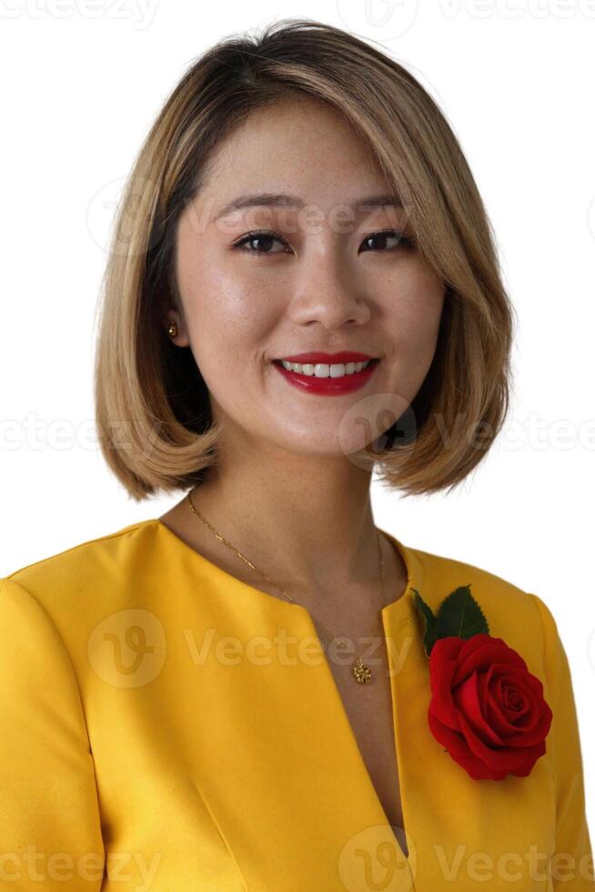 A photograph of an Asian woman with a bob haircut, wearing a yellow dress, red rose pin, and red lipstick. photo