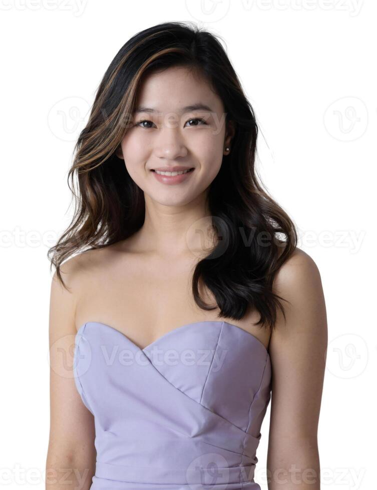 A young Asian woman with long, dark hair smiles, wearing a lavender strapless dress, against a light background. photo
