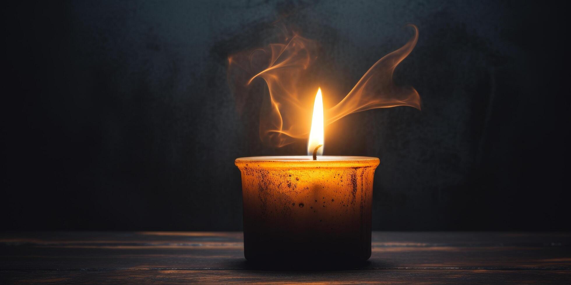 Glowing candle flame with smoke in the dark photo