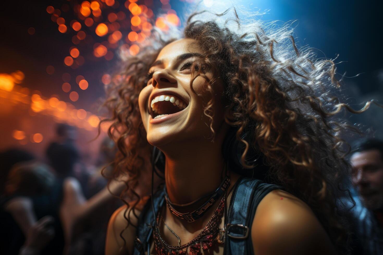 Joyful woman with curly hair laughing in front of colorful lights photo