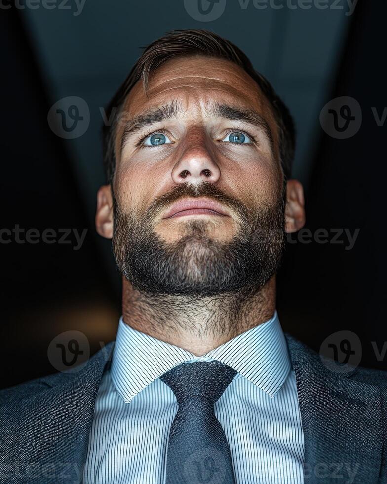 Confident businessman looking up, thinking about the future photo