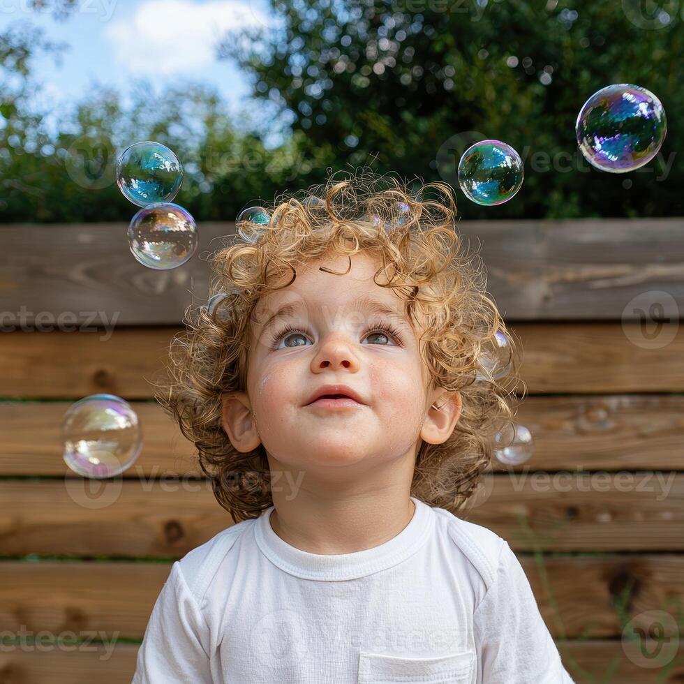 Toddler looking up at bubbles photo