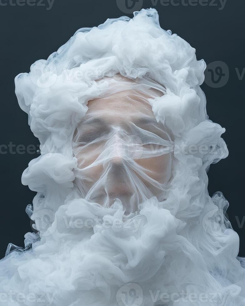 Mysterious womans face hidden behind a white cloud of smoke and sheer fabric photo