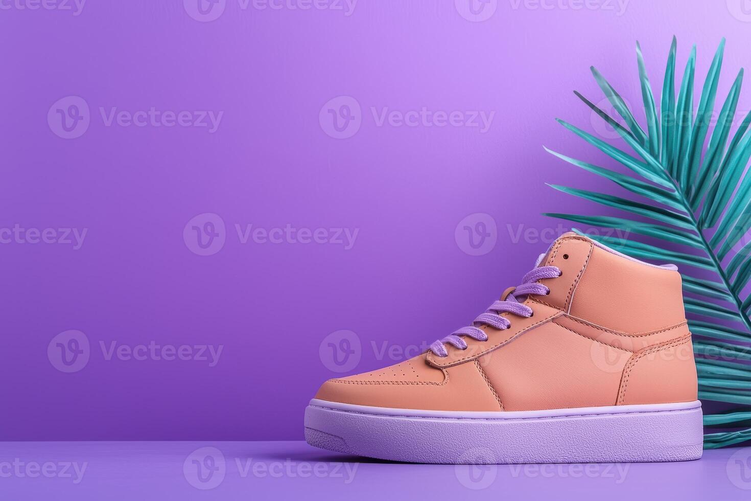 Stylish peach high top sneakers with purple laces and a palm leaf on a purple background photo