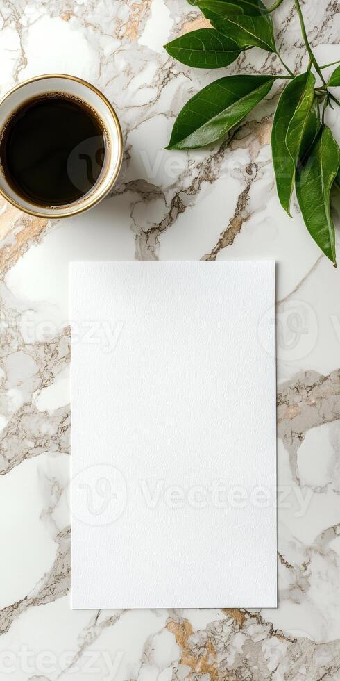 Blank white paper mockup on marble background with coffee and green leaves photo
