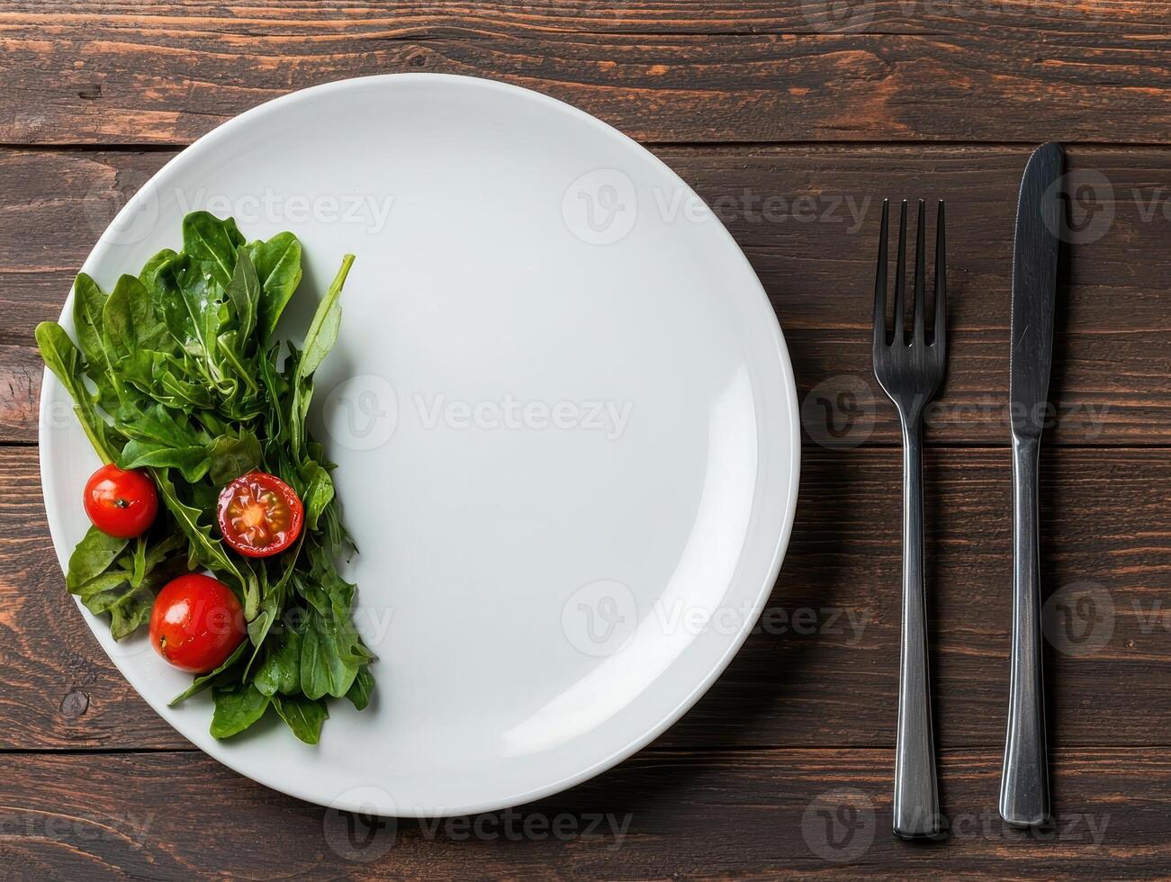 Small portion of arugula salad with cherry tomatoes on a white plate photo