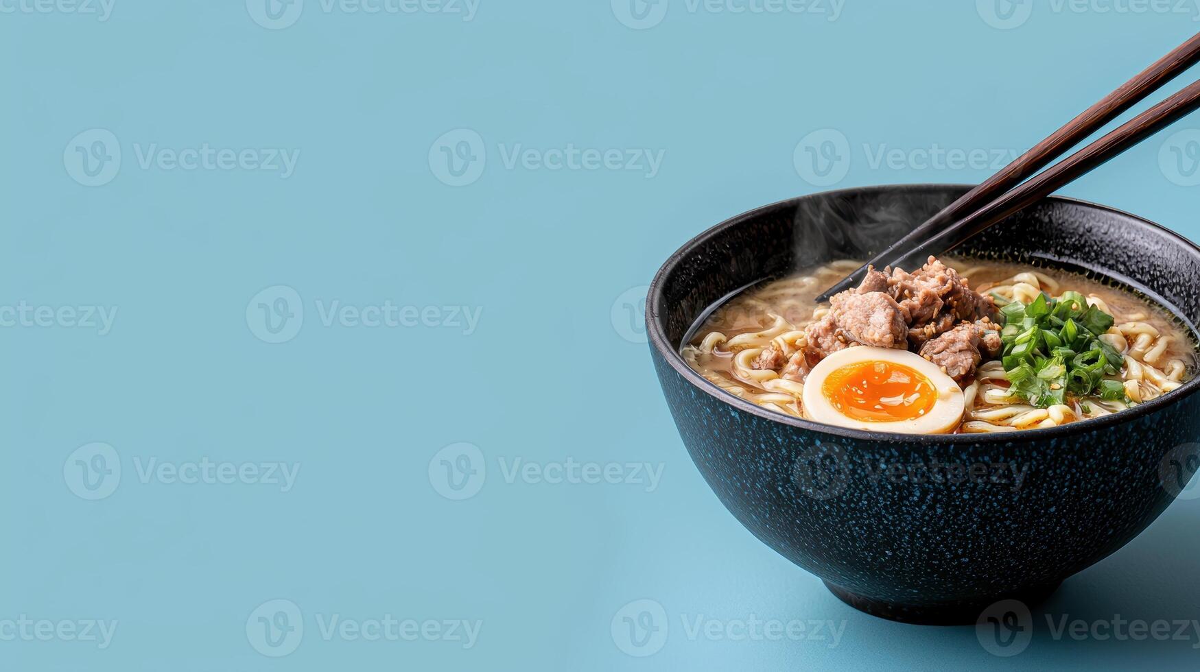 Steaming bowl of ramen noodles with pork, egg, and green onions photo