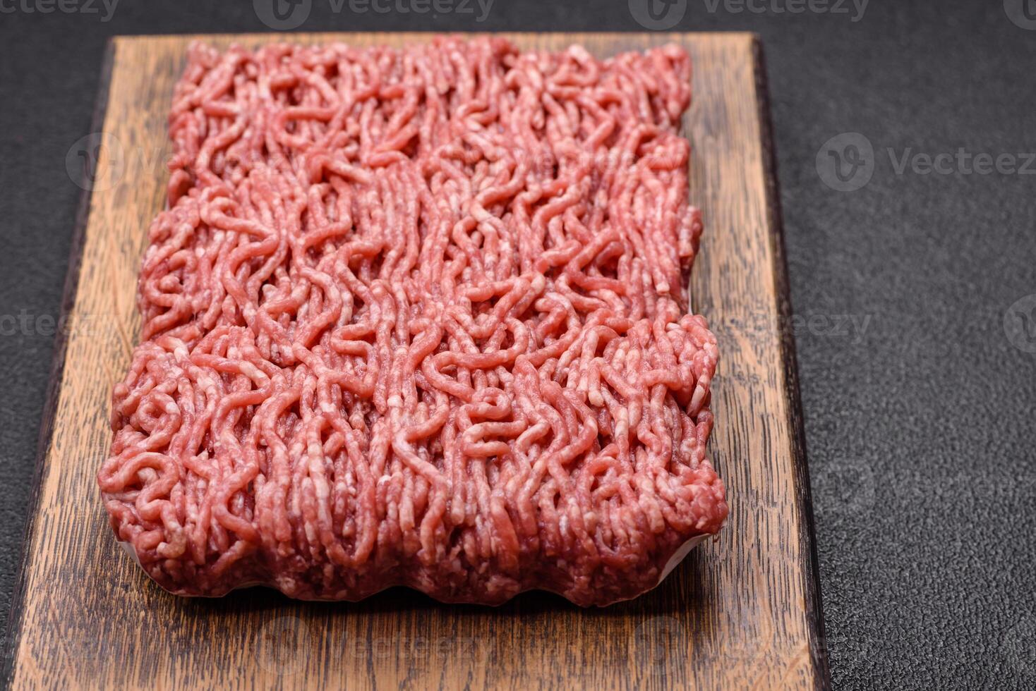Fresh raw ground minced beef with salt and spices photo