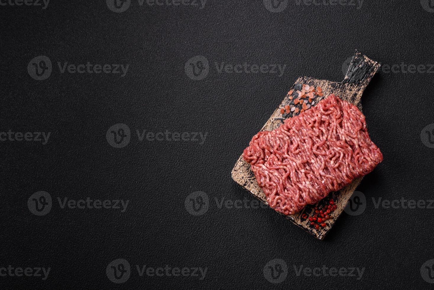 Fresh raw ground minced beef with salt and spices photo