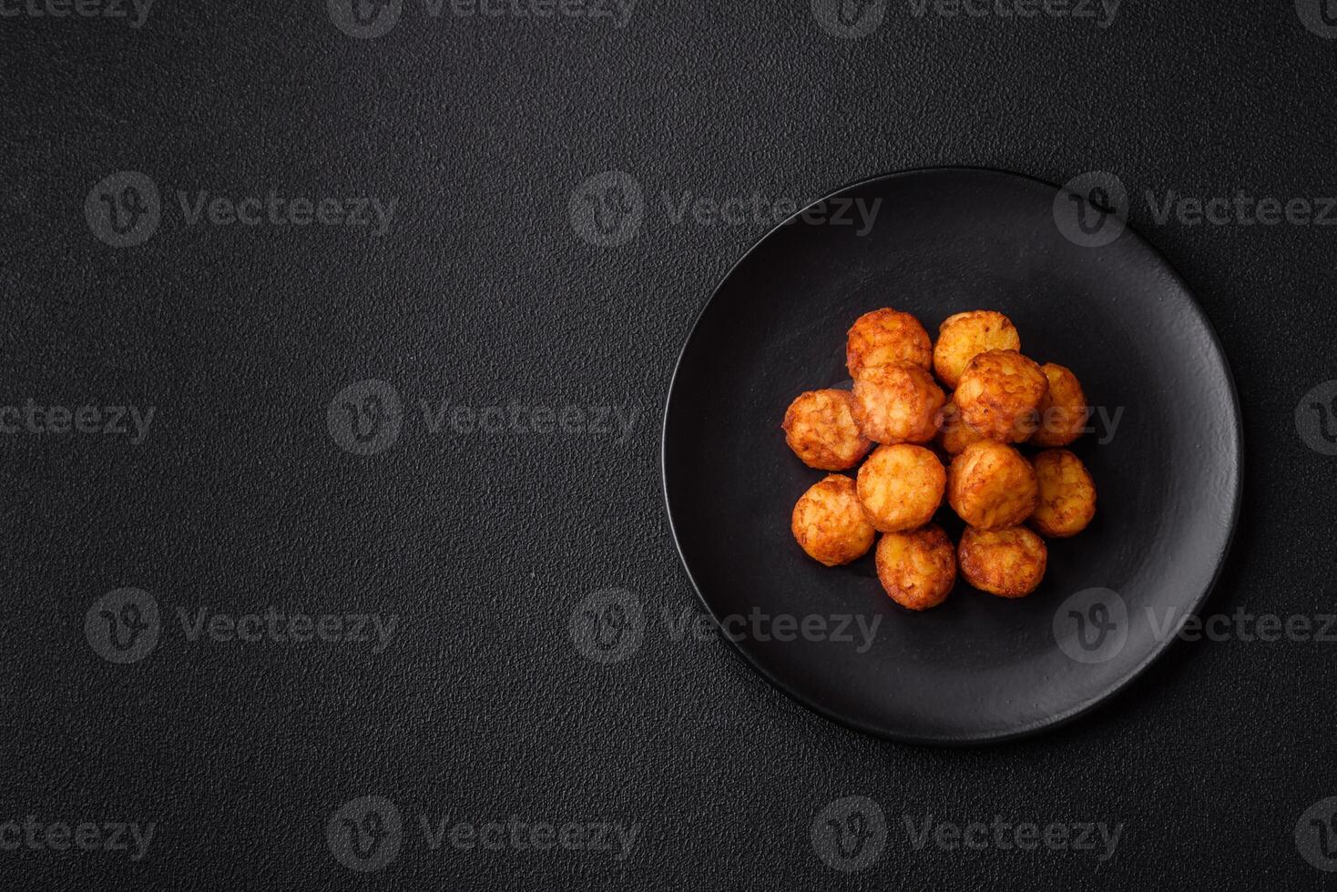 Delicious fried potato balls or croquettes with salt, spices and herbs photo