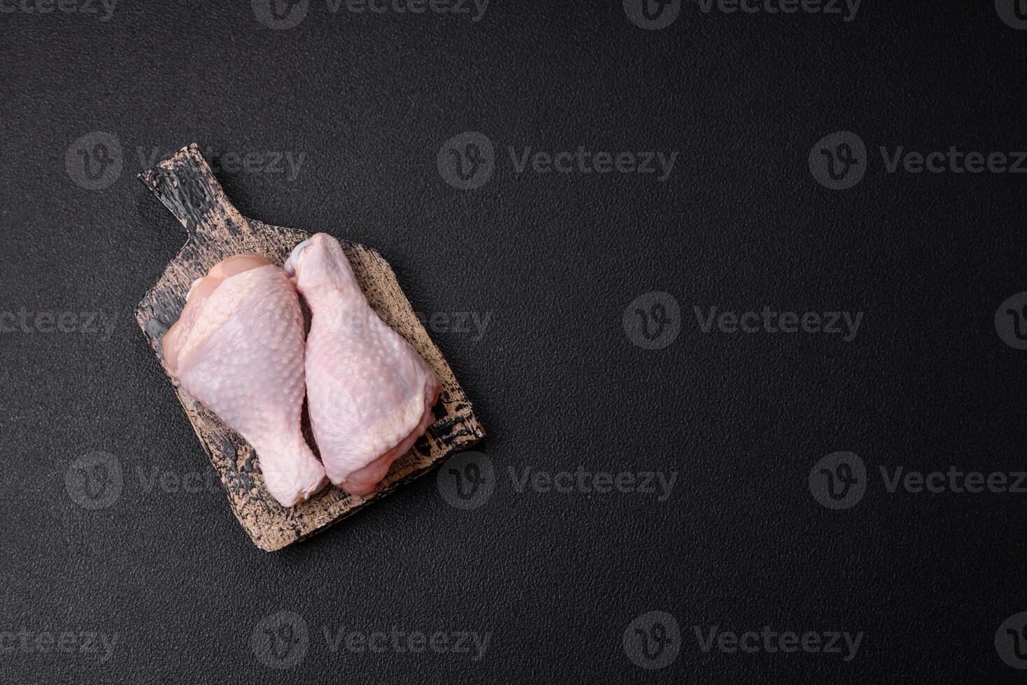 Raw chicken legs with salt, spices and herbs photo
